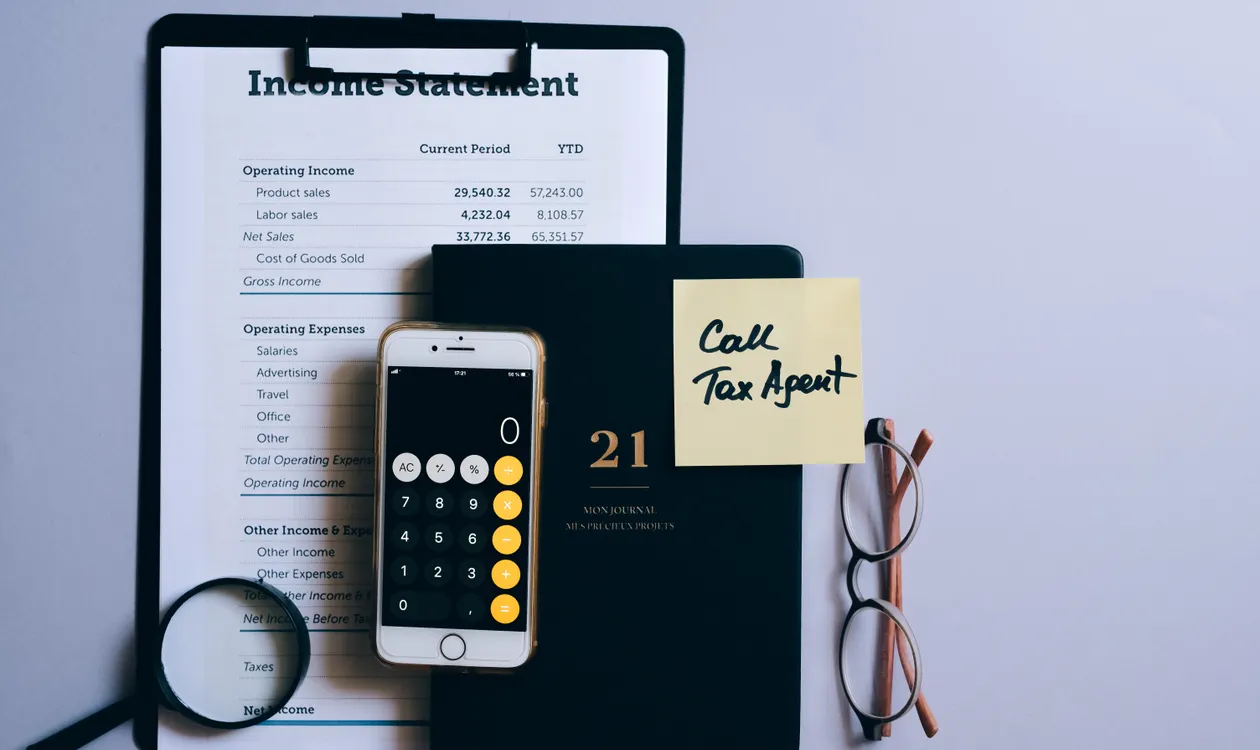 Calculator resting on a payroll income statement document
