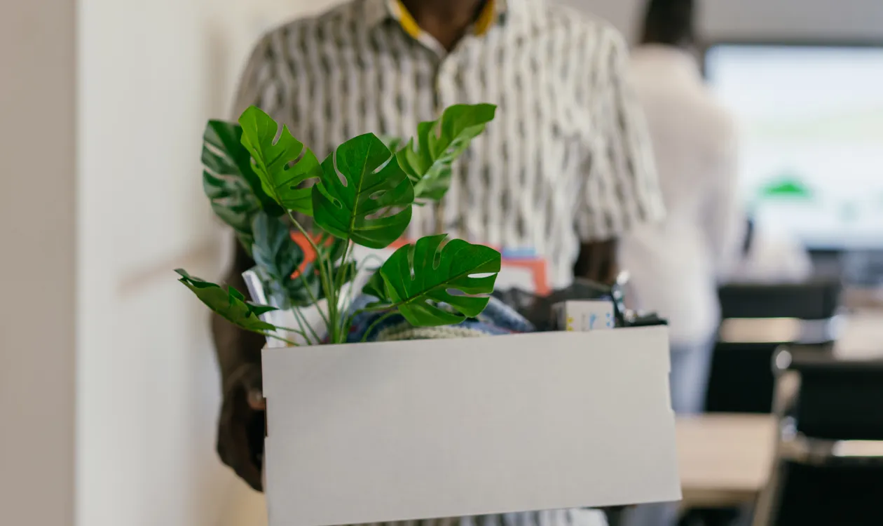 Employee packing personal belongings into a box after redundancy
